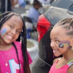 two children with colorful face paint smiling