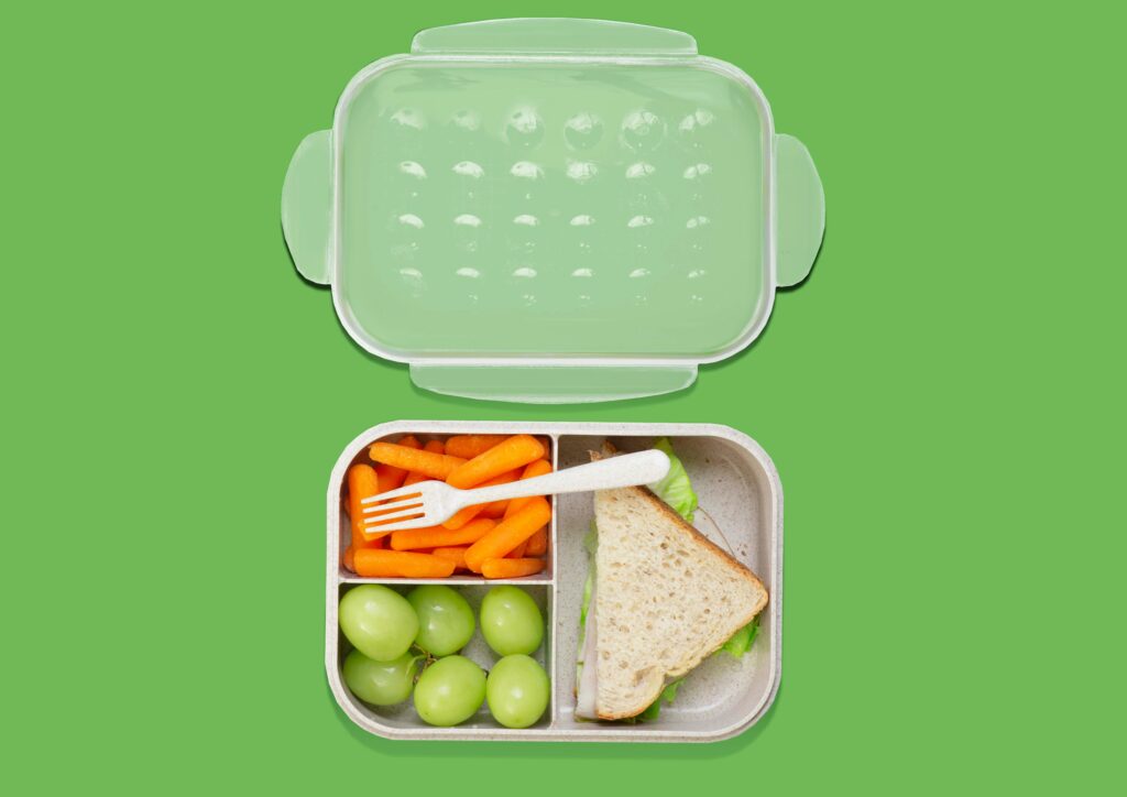 A healthy lunchbox with grapes and carrots, representing the nutrition goals of TheWash Youth Foundation.